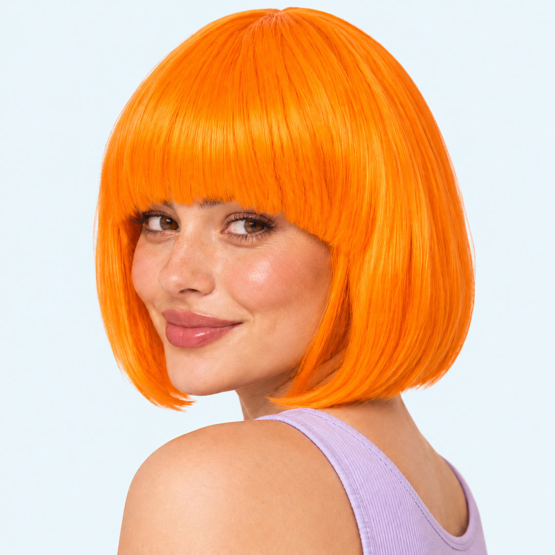 Model wearing an orange straight bob wig with full fringe.