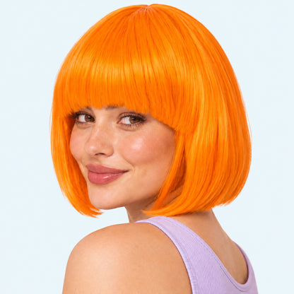 Model wearing an orange straight bob wig with full fringe.