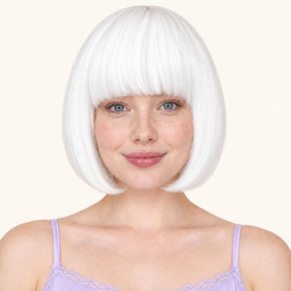 Model wearing a white straight bob wig with full fringe.